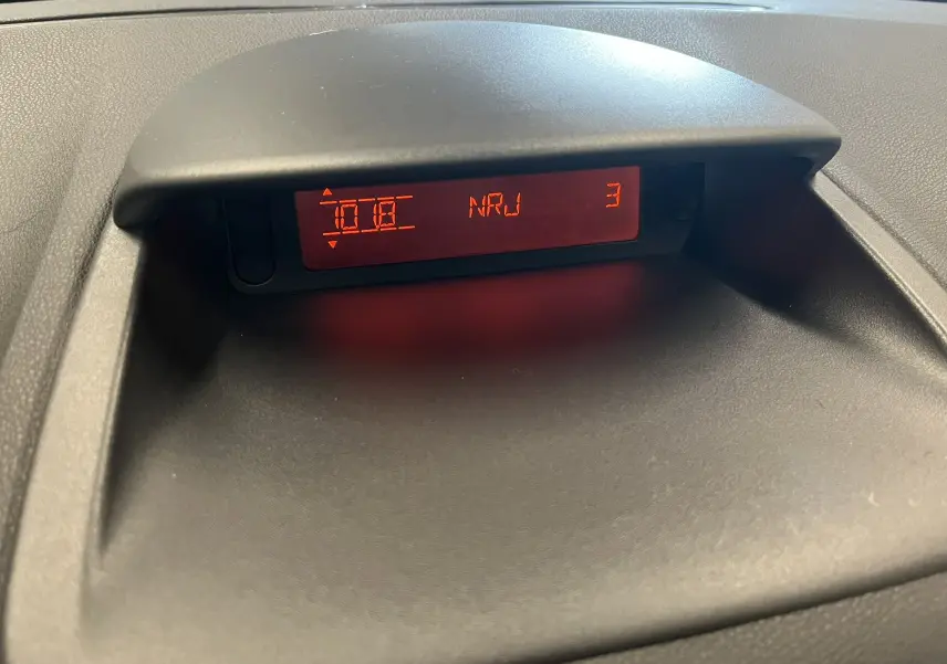 Affichage central rouge du système audio de la Renault Clio III RS 20th Anniversary, vue rapprochée du tableau de bord.