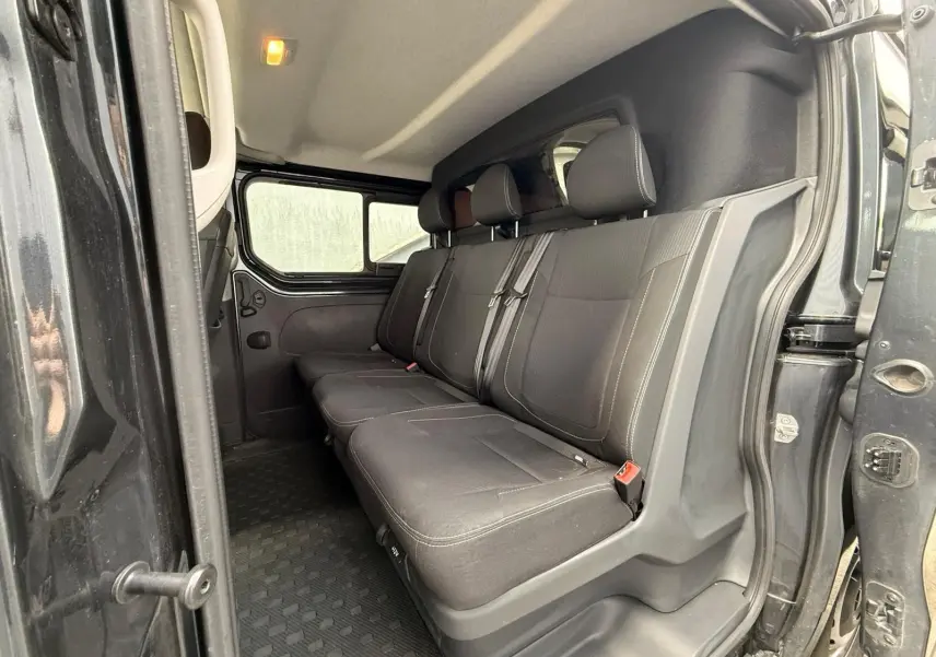 Vue intérieure côté droit montrant la banquette arrière noire du Renault Trafic Cabine Approfondie gris comète.
