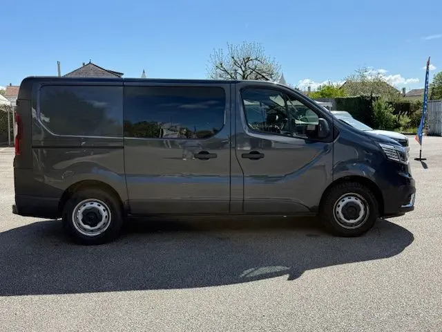 Vue latérale droite d’un Renault Trafic Cabine Approfondie gris comète avec portes latérales vitrées et jantes acier.