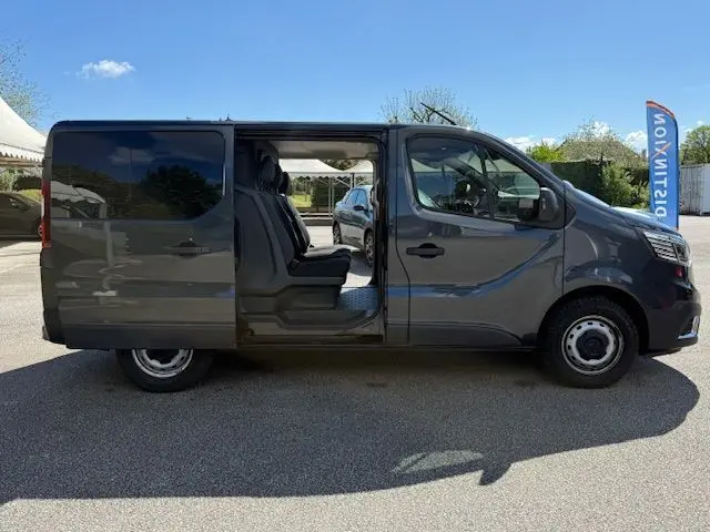 Vue de profil droit du Renault Trafic Cabine Approfondie gris comète avec porte latérale ouverte dévoilant l'intérieur.