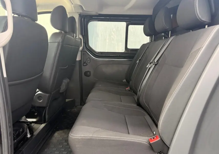 Vue intérieure côté droit sur la banquette arrière noire du Renault Trafic Cabine Approfondie gris comète 2024.