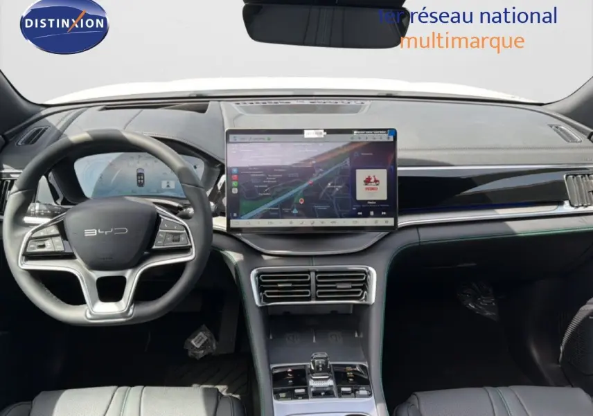 Vue intérieure avant du tableau de bord et volant du BYD SEAL U blanc métal, avec écran tactile central et finitions modernes.