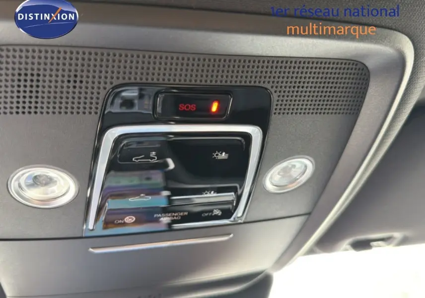 Vue en gros plan du panneau de commandes de toit intérieur du BYD SEAL U blanc métal, avec bouton SOS et éclairage intégré.