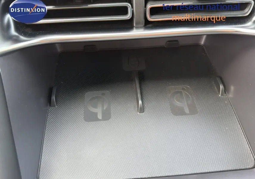 Gros plan sur le chargeur sans fil Qi intégré dans la console centrale du BYD SEAL U blanc métal 2026.