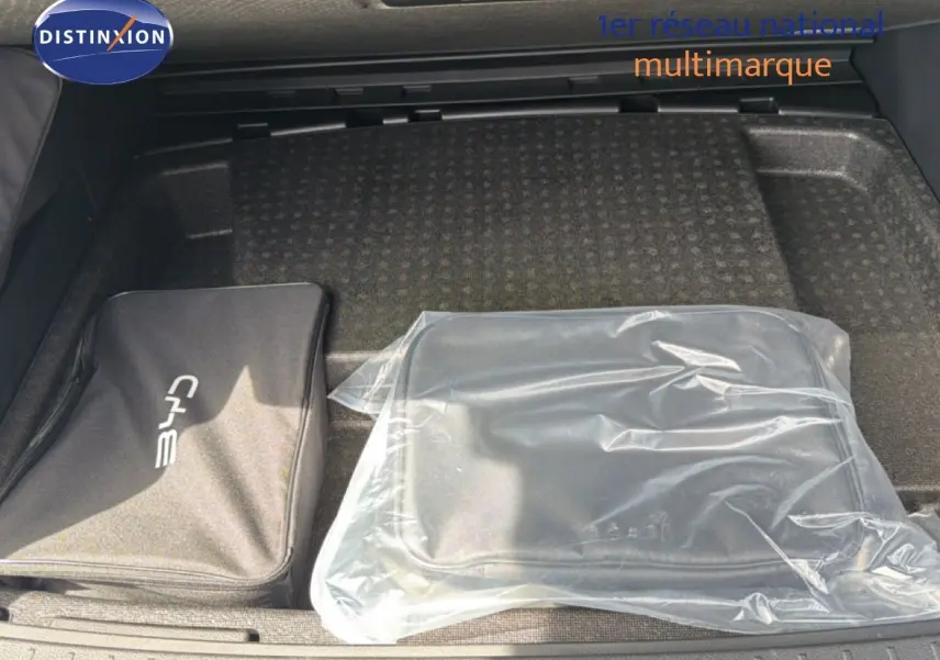 Coffre ouvert du BYD SEAL U blanc métal 2026 montrant deux sacs de rangement, dont un sous plastique transparent.