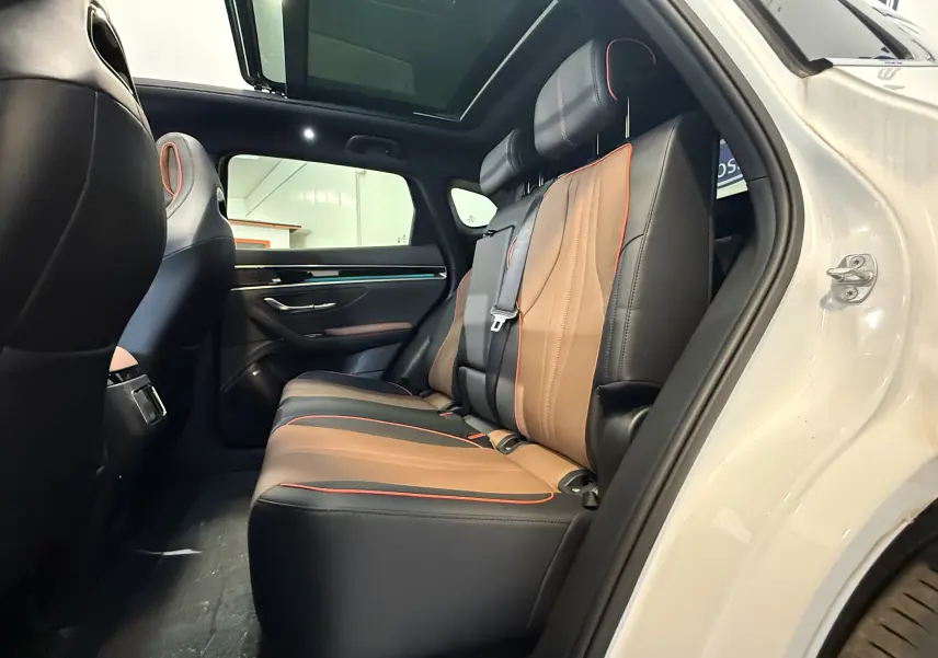 Vue intérieure côté droit des sièges arrière en cuir bicolore marron et noir avec surpiqûres rouges du BYD SEAL U blanc métal 2026.