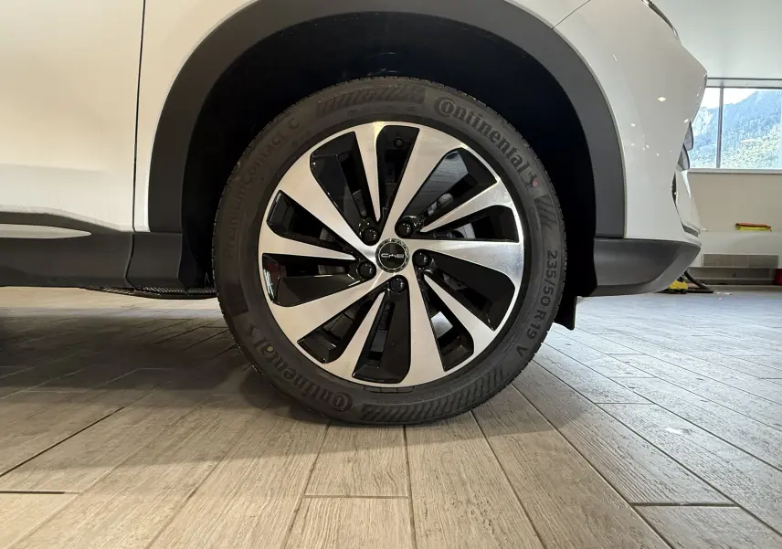 Gros plan sur la roue avant droite du BYD SEAL U blanc métal, jante alliage bicolore et pneu Continental.