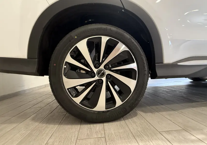 Gros plan sur la roue avant droite du BYD SEAL U blanc métal, avec jante bi-ton noire et argentée au design moderne.