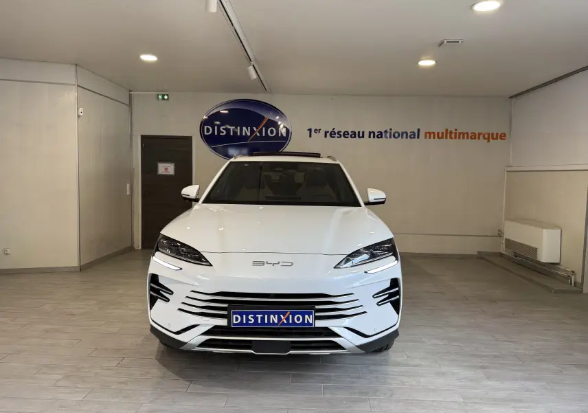 Vue avant du BYD SEAL U blanc métal, mettant en valeur sa calandre horizontale et ses phares LED fins dans un showroom.