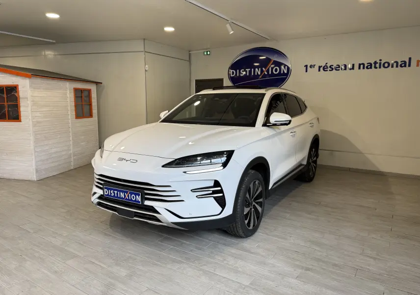 Vue 3/4 avant droite du SUV BYD SEAL U blanc métal, avec calandre moderne et jantes alliage bicolores dans un showroom.