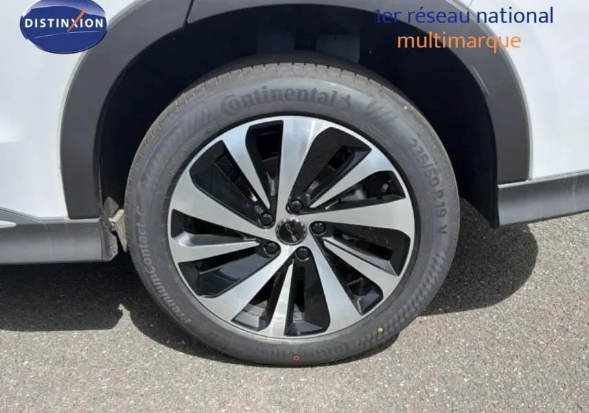 Gros plan sur la roue avant droite d’un BYD SEAL U blanc métal avec jante alliage bicolore et pneu Continental.