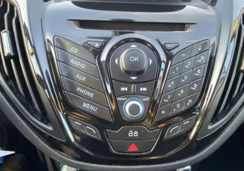 Gros plan sur la console centrale noire du Ford B-MAX 2014 avec commandes audio et téléphone intégrées.