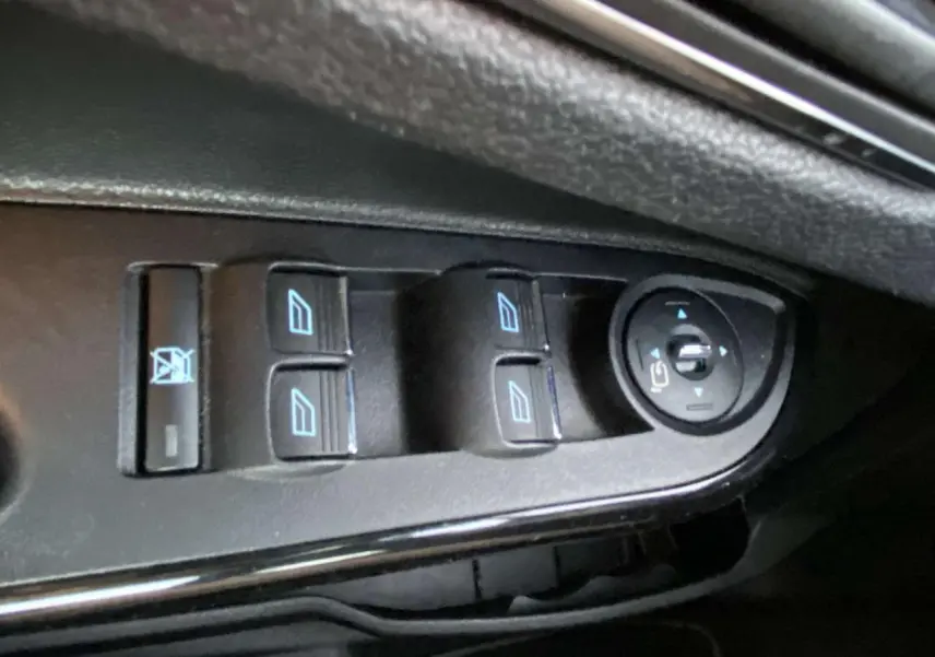 Gros plan sur les commandes des vitres et des rétroviseurs côté conducteur d'une Ford B-MAX blanche 2014.