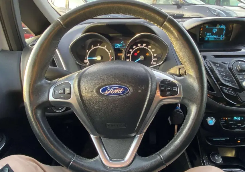 Vue intérieure centrée sur le volant Ford B-MAX 2014 avec tableau de bord et commandes au volant visibles.