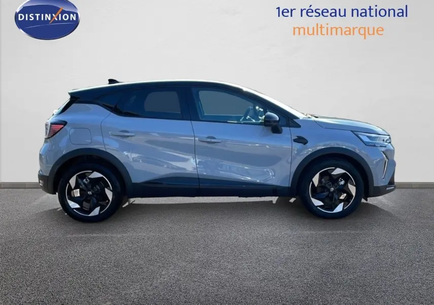 Profil côté gauche du Renault Captur E-Tech hybride 2025 gris Rafale avec toit noir et jantes noires distinctives.