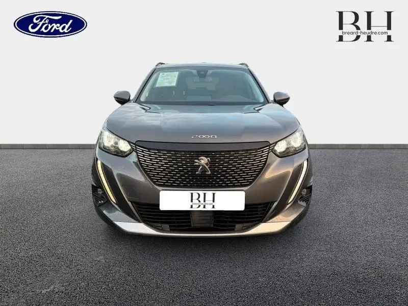 Peugeot 2008 gris Artense vue de face, mettant en valeur sa calandre distinctive et ses feux LED élégants.