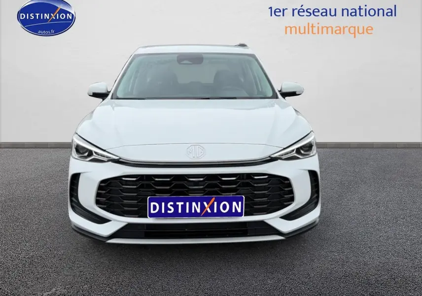 Vue frontale d’un MG ZS Hybrid blanc 2026 avec calandre noire et phares LED fins, sur fond neutre.