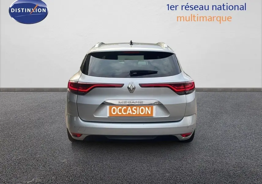 Vue arrière d'une Renault Mégane Break gris Highland Metal de 2024 avec feux LED étirés et plaque occasion.
