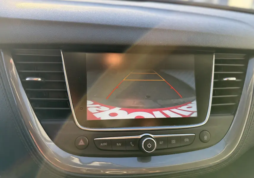 Écran central de l’Opel Grandland X 2019 montrant l’image de la caméra de recul avec les lignes de guidage rouges et jaunes.