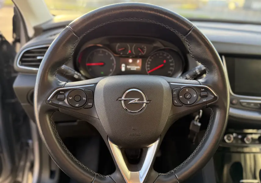 Vue rapprochée du volant en cuir noir avec commandes intégrées de l'Opel Grandland X 2019 diesel gris quartz.