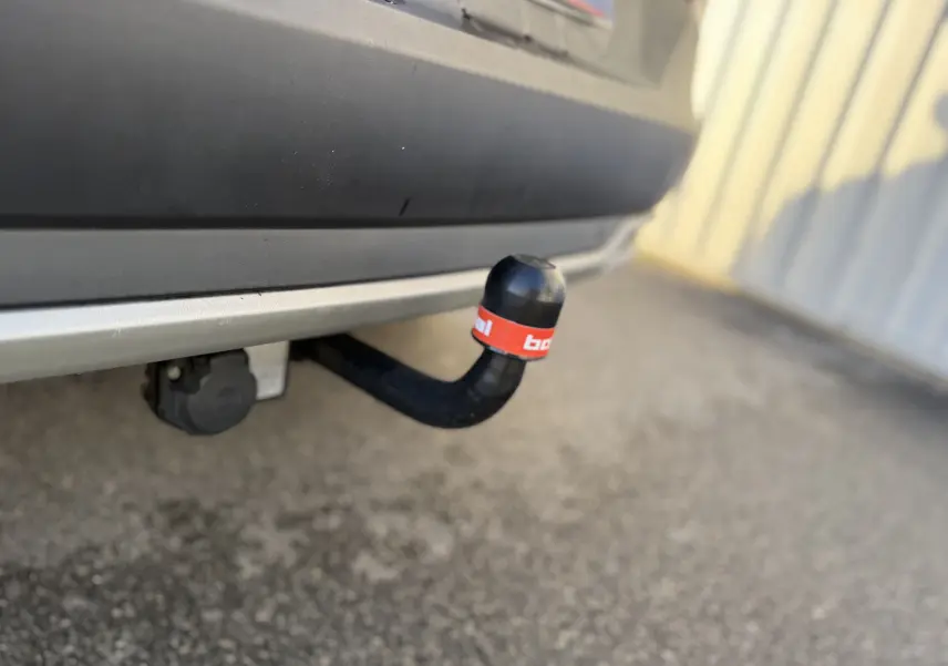 Gros plan sur l'attelage noir avec protection rouge sous le pare-chocs arrière gris quartz d'un Opel Grandland X 2019.