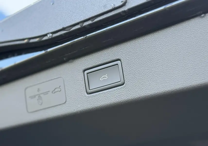 Gros plan sur le bouton d'ouverture électrique du hayon du Volkswagen T-Roc noir Ébène, version 2026.