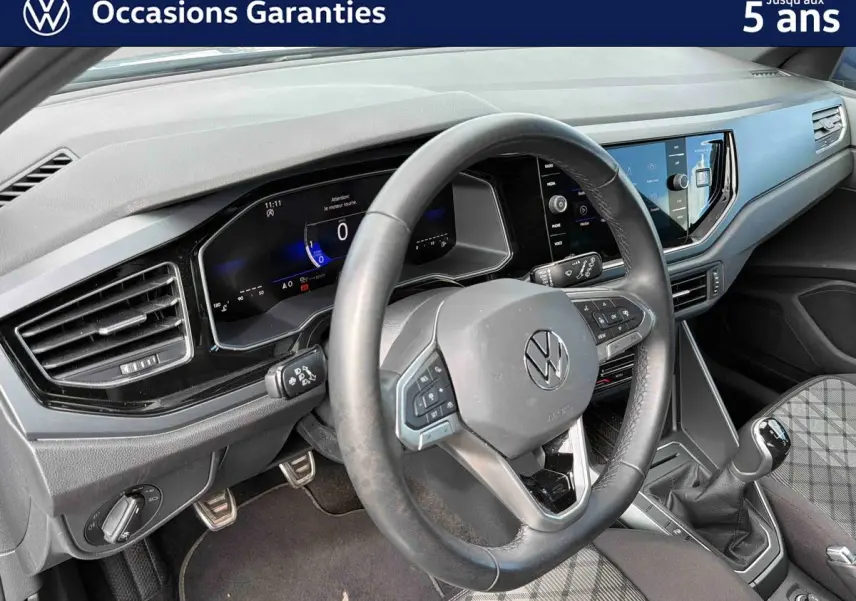 Vue intérieure du poste de conduite de la Volkswagen Polo 2025, volant cuir multifonctions et tableau de bord digital.