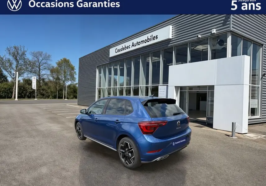 Vue 3/4 arrière droite d'une Volkswagen Polo 2025 bleu récif métallisée avec toit noir et jantes alliage 17 pouces.