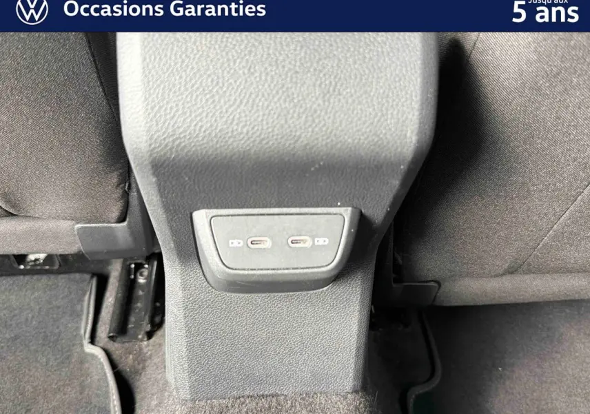 Vue rapprochée des ports USB-C situés à l'arrière de la console centrale entre les sièges arrière d'une Volkswagen Polo bleue.
