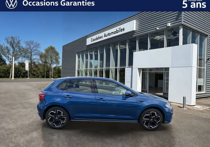 Volkswagen Polo 2025 bleu métallisé vue de profil côté gauche devant un bâtiment de concession.