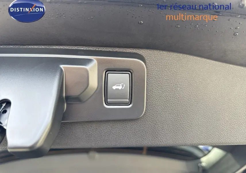 Bouton d'ouverture électrique du coffre sur le hayon intérieur d'un Renault Austral gris schiste métal toit noir.