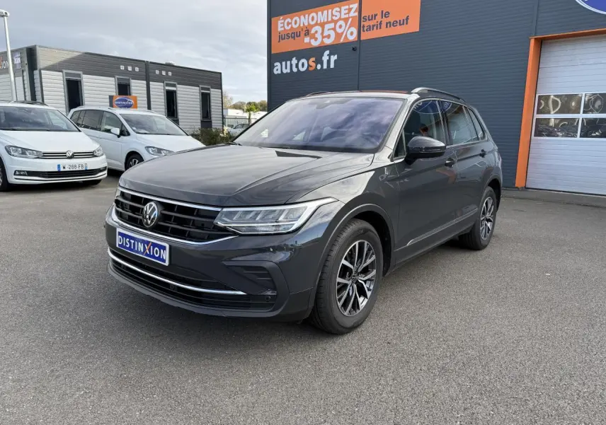 Volkswagen Tiguan gris Urano en 3/4 avant droit, avec jantes alliage Dark Graphite et calandre chromée.