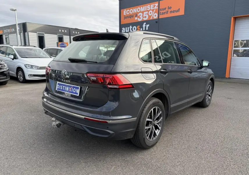 Volkswagen Tiguan 2.0 TDI gris Urano vu en 3/4 arrière droit avec crochet d'attelage et jantes alliage Tulsa.