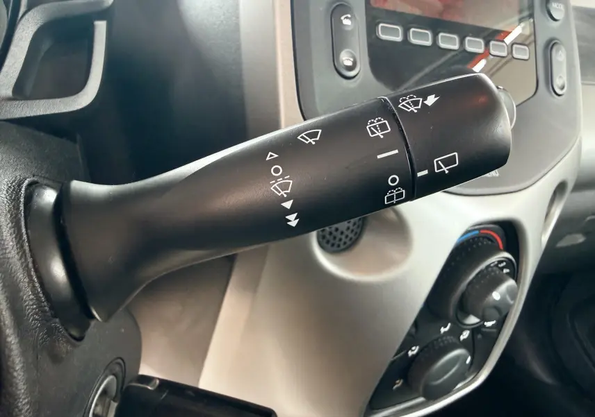 Gros plan sur la commande des essuie-glaces dans l'habitacle gris clair d'une Peugeot 108 noire de 2018.