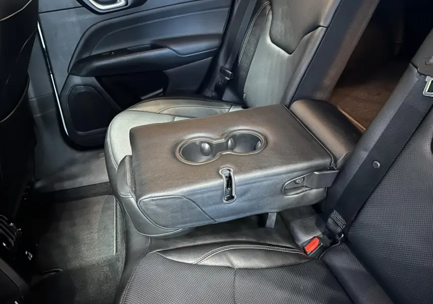 Vue intérieure côté droit de la banquette arrière cuir noir ventilé avec accoudoir central et porte-gobelets du Jeep Compass 2024.