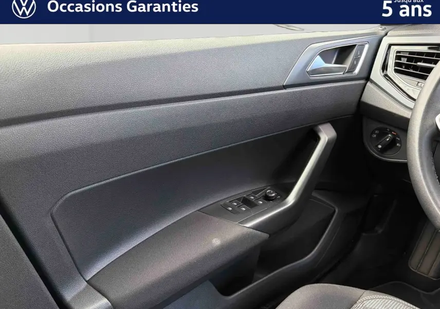 Vue rapprochée de la porte avant gauche intérieure de la Volkswagen Polo 2025 avec commandes électriques et poignée angulaire.