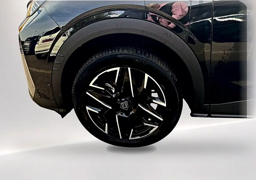 Gros plan sur la roue avant gauche noire du Peugeot 5008 Hybrid 145 GT e-dcs6 noir avec jante alu stylisée.