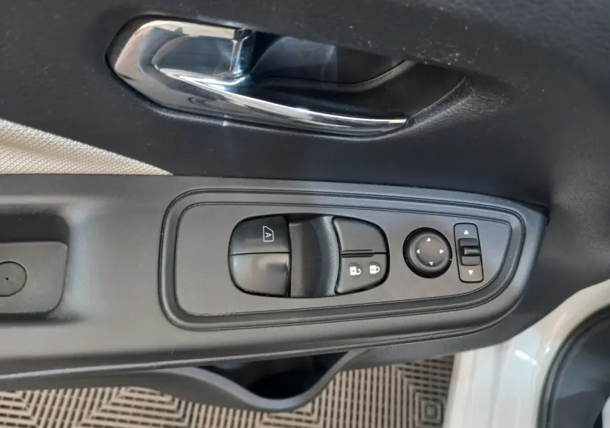 Gros plan sur la commande de lève-vitres et rétroviseurs côté conducteur de la Nissan Micra blanche 2018.