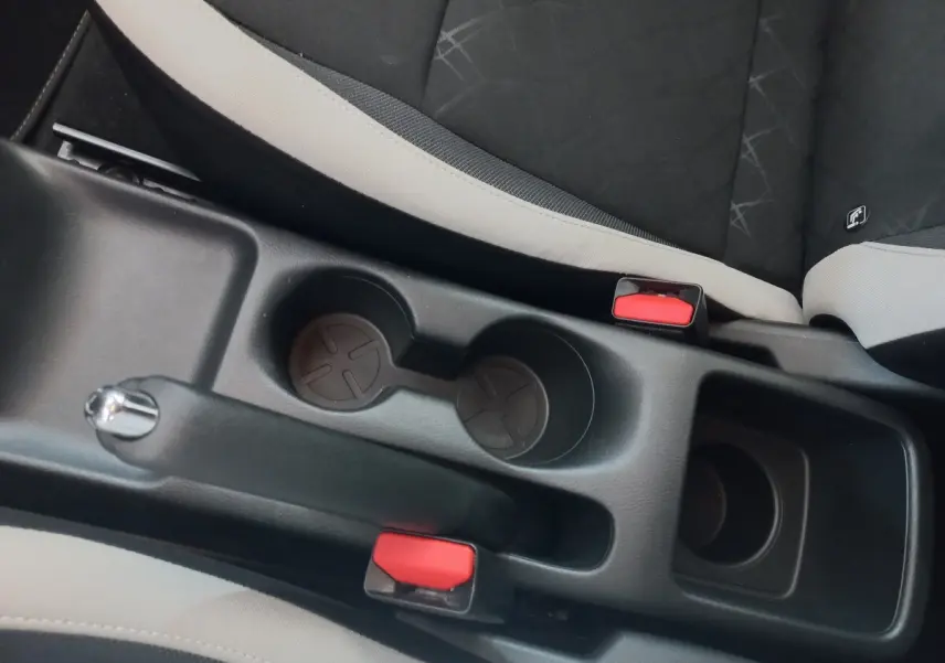 Vue rapprochée de la console centrale noire entre les sièges avant gris et noir de la Nissan Micra IG-T 90 Business Edition.