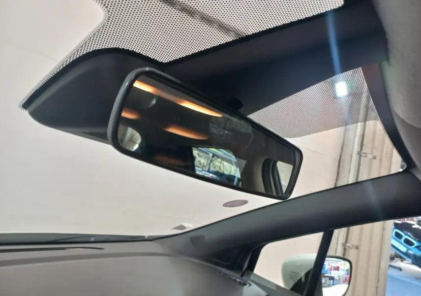 Vue intérieure du rétroviseur central et du pare-brise d’une Nissan Micra blanche, avec rétroviseur latéral droit visible.