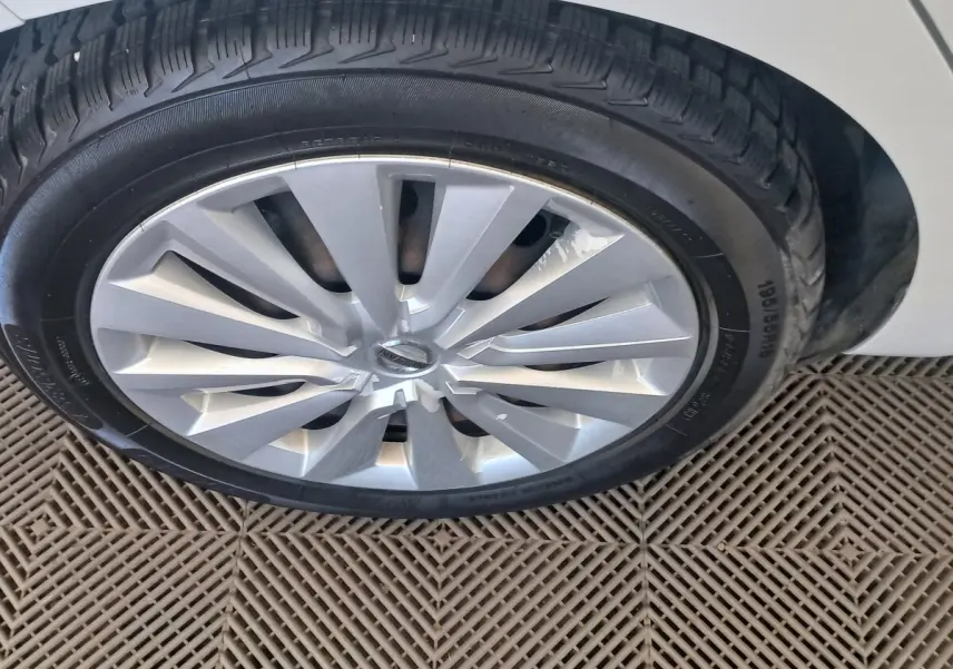 Gros plan sur la roue avant droite de la Nissan Micra blanche, jante en alliage au design moderne.