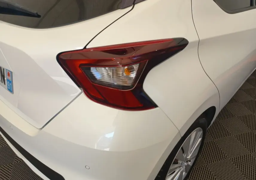 Vue arrière droite d'une Nissan Micra blanche 2018, mettant en valeur le feu arrière et la jante alliage.