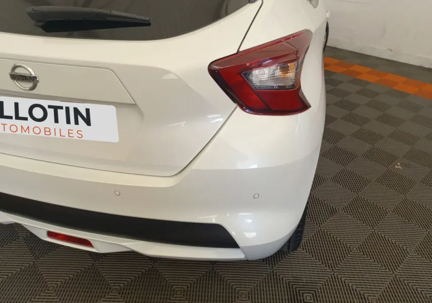 Vue arrière droite d'une Nissan Micra blanche 2018 avec feux arrière distinctifs et capteurs de stationnement intégrés.