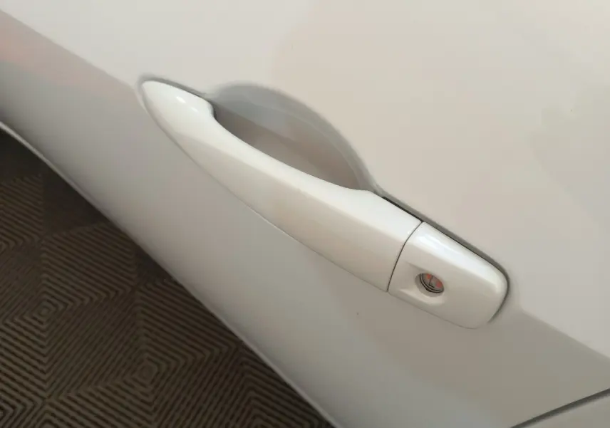Poignée de porte blanche côté droit d'une Nissan Micra IG-T 90 Business Edition 2018 vue en gros plan.