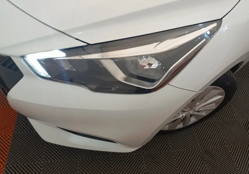 Gros plan sur le phare avant droit blanc de la Nissan Micra IG-T 90 Business Edition 2018 avec jante alliage visible.