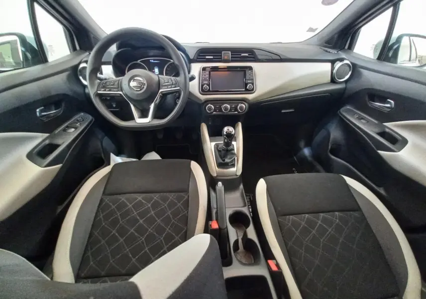 Vue intérieure avant de la Nissan Micra IG-T 90 Business Edition 2018, tableau de bord noir et beige avec volant multifonctions.
