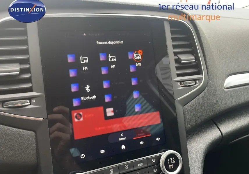 Vue rapprochée de l'écran tactile central et de la console d'une Renault Mégane Break gris Highland Metal, intérieur moderne.