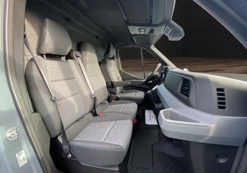 Vue intérieure côté gauche du Renault Master 2025 gris urbain, montrant les sièges avant et le tableau de bord.