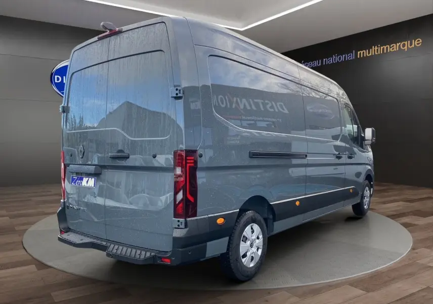 Vue 3/4 arrière droit du Renault Master gris urbain 2025 avec hayon et feux arrière verticaux allumés.