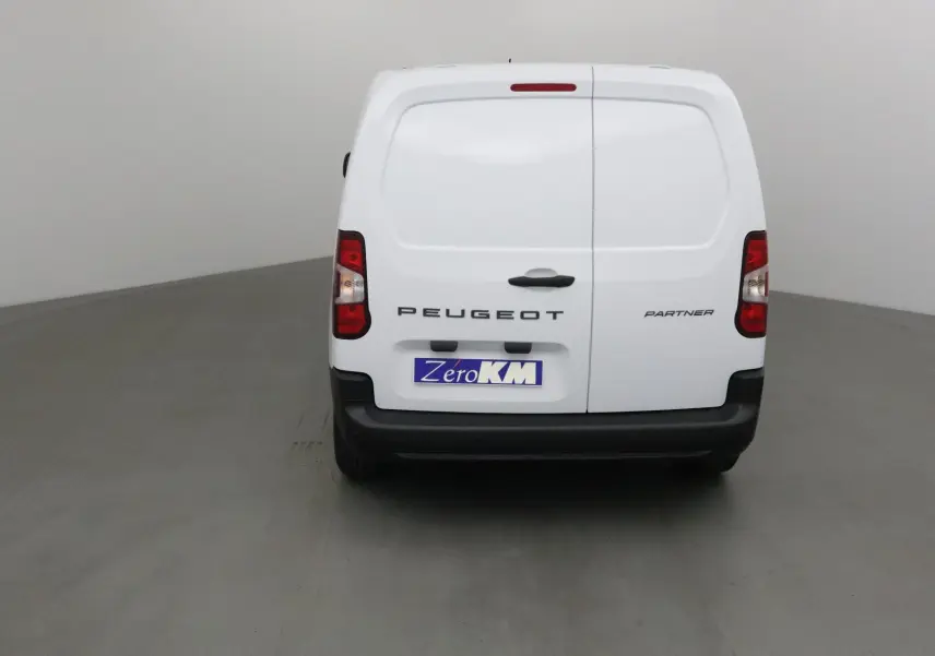 Vue arrière du Peugeot Partner blanc 2025 avec portes battantes et logo visible sur fond neutre.